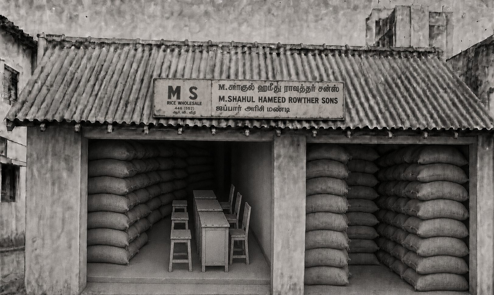 The 1985 storefront with the MS board in Tamil and English above stacked rice sacks